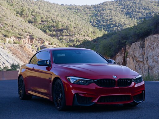 A red BMW M4 with mountains in the background